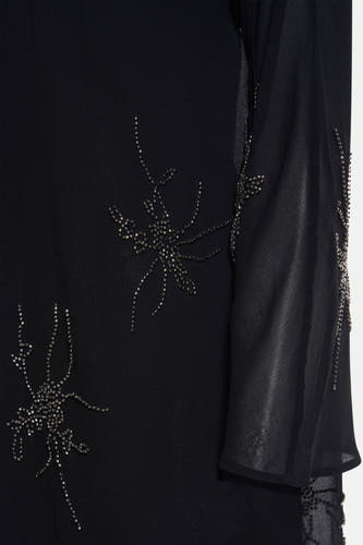 Zwarte jurk met lange mouwen van Astrid Black Label, versierd met kraaldetails in bloemmotieven.
