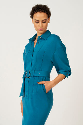 Robe bleue à longues manches d'Astrid Black Label, avec une ceinture et des chaussures noires à strass.