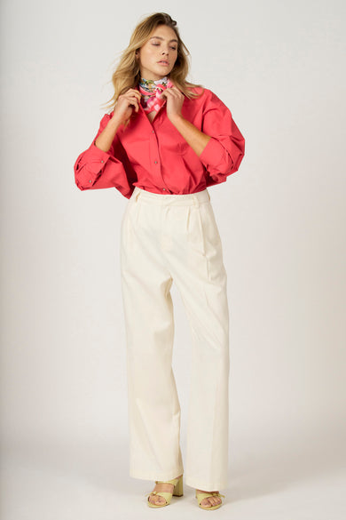 Roze hemd met lange mouwen van Astrid Black Label, met een sjaaltje en gecombineerd met een witte pantalon.