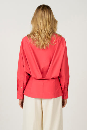 Roze hemd met lange mouwen van Astrid Black Label, gezien van achteren, gecombineerd met een crèmekleurige broek.
