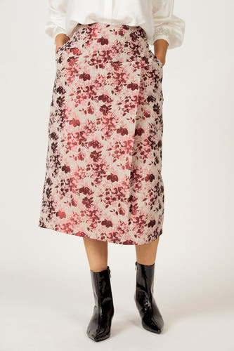Roze rok van Astrid Black Label met bloemenprint, steekzakken en zwarte enkellaarsjes.