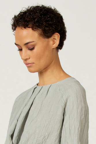 Blauw shirt met lange mouwen van Astrid Black Label, met geplooide details en subtiele textuur.