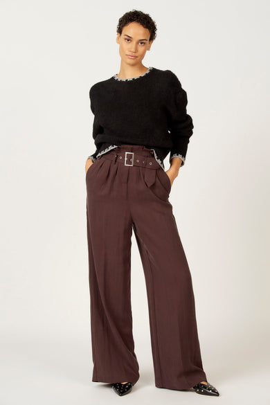 Zwarte trui met ronde hals van Astrid Black Label, met decoratieve randen en gecombineerd met bruine, wijde broek.