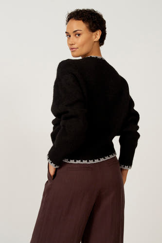 Zwarte trui met ronde hals van Astrid Black Label, met zilverkleurige details aan de zoom en manchetten.