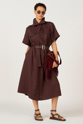 Bruine jurk met korte mouwen van Astrid Black Label, met een riem met zilveren details en een bruine tas met franjes.