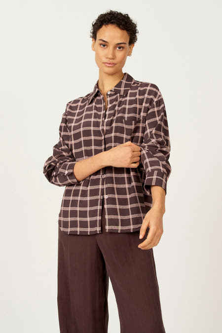 Bruine blouse met lange mouwen van Astrid Black Label, met ruitpatroon in lichtroze, gedragen met bruine broek.