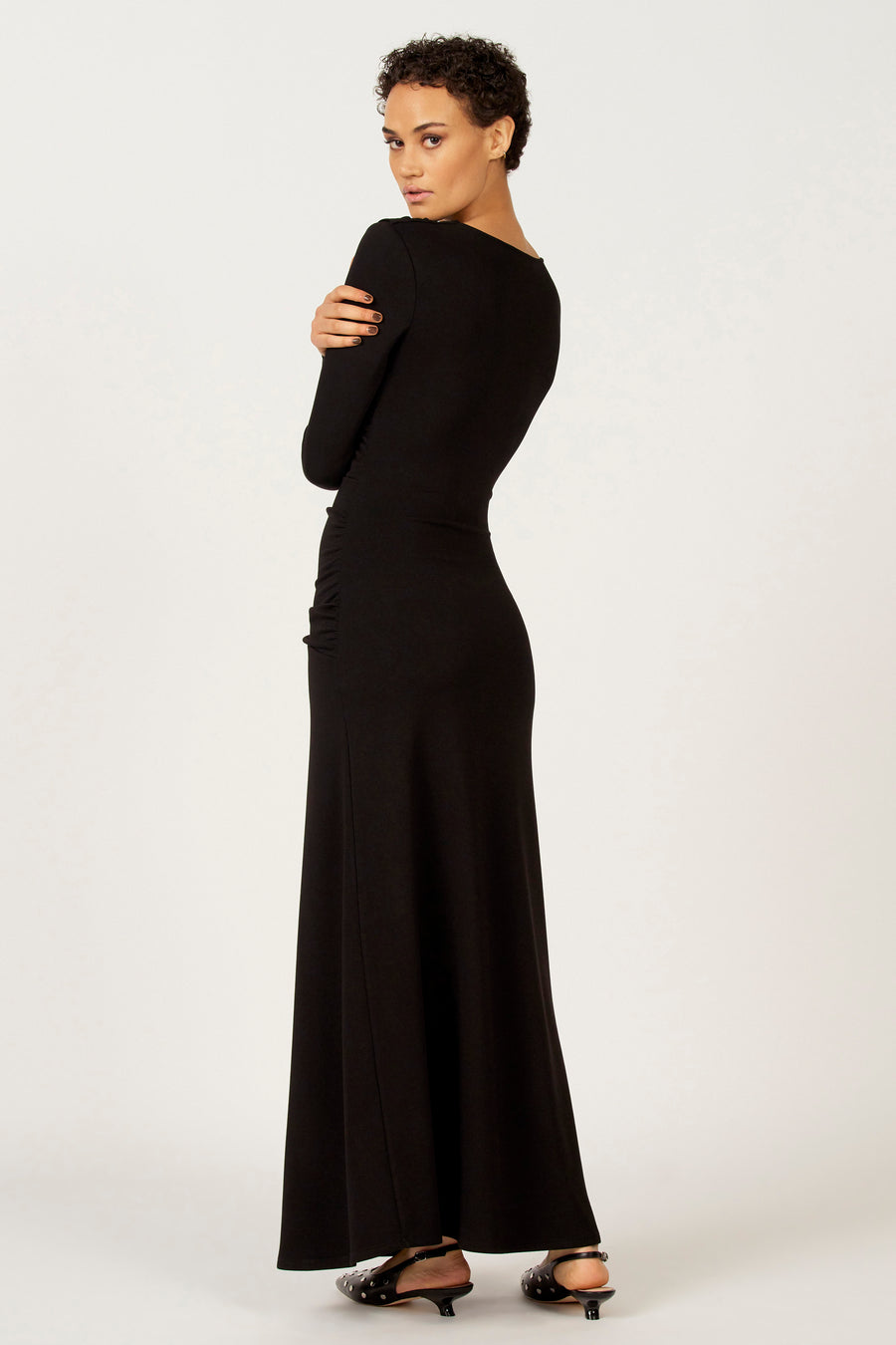Robe noire à longues manches d'Astrid Black Label, modèle tailleur avec des plis sur les côtés.