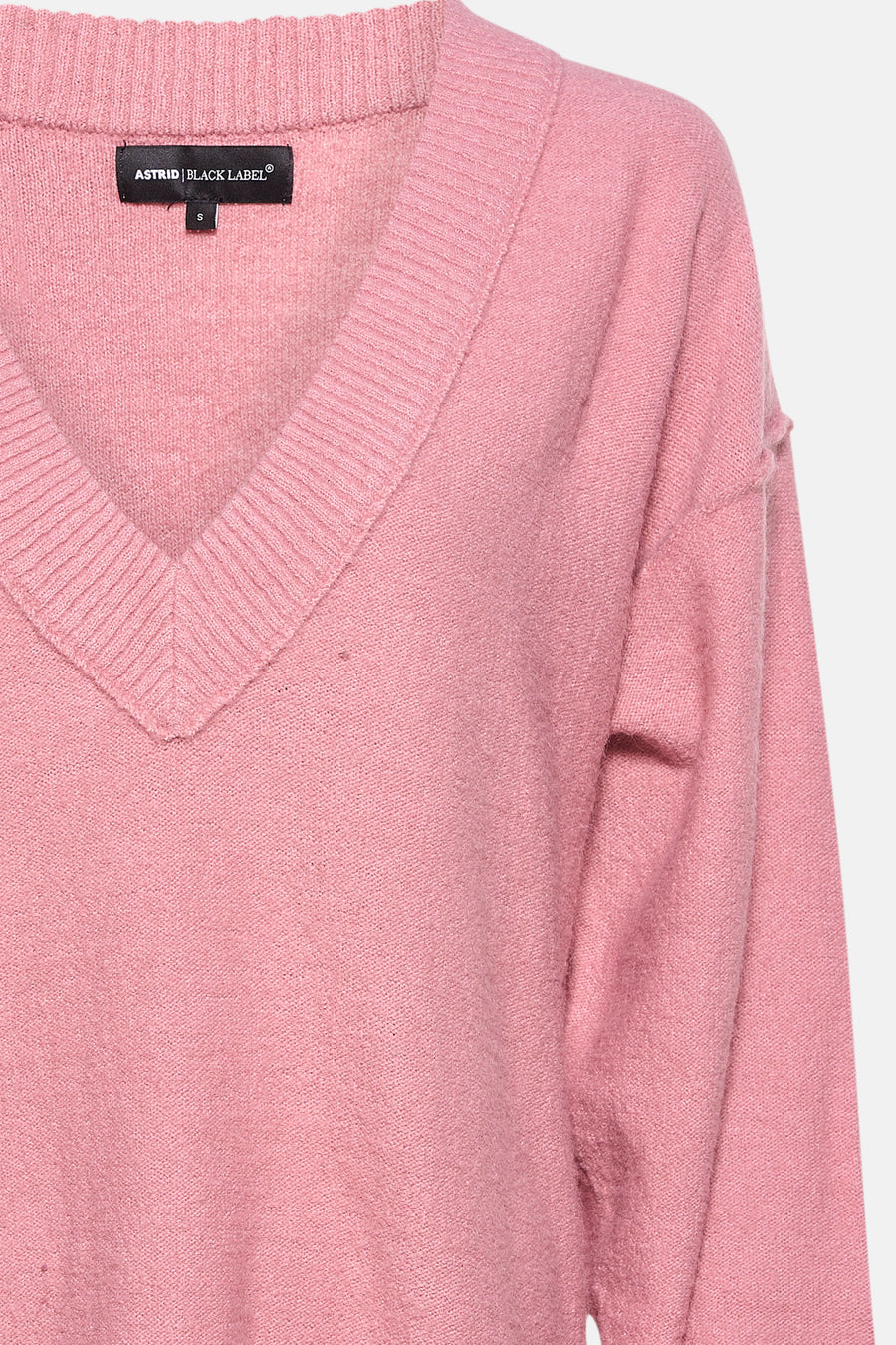 Gilet V-hals rose d'Astrid Black Label, avec une finition côtelée le la ligne du col.