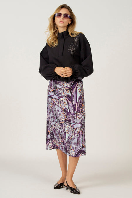 Zwarte sweater van Astrid Black Label, met lange mouwen, hoge kraag en decoratieve accenten.