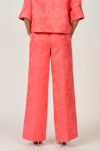 Roze broek van Astrid Black Label, met een all-over bloemmotief en wijde pijpen.
