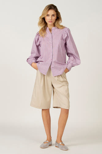 Chemise rose à rayures à manches longues d'Astrid Black Label, avec des manches bouffantes et portée avec un pantalon beige mi-long.
