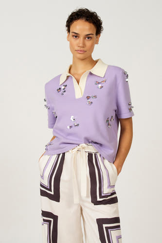 Polo marron avec manches courtes d'Astrid Black Label, avec col blanc et imprimé graphique sur la jupe.