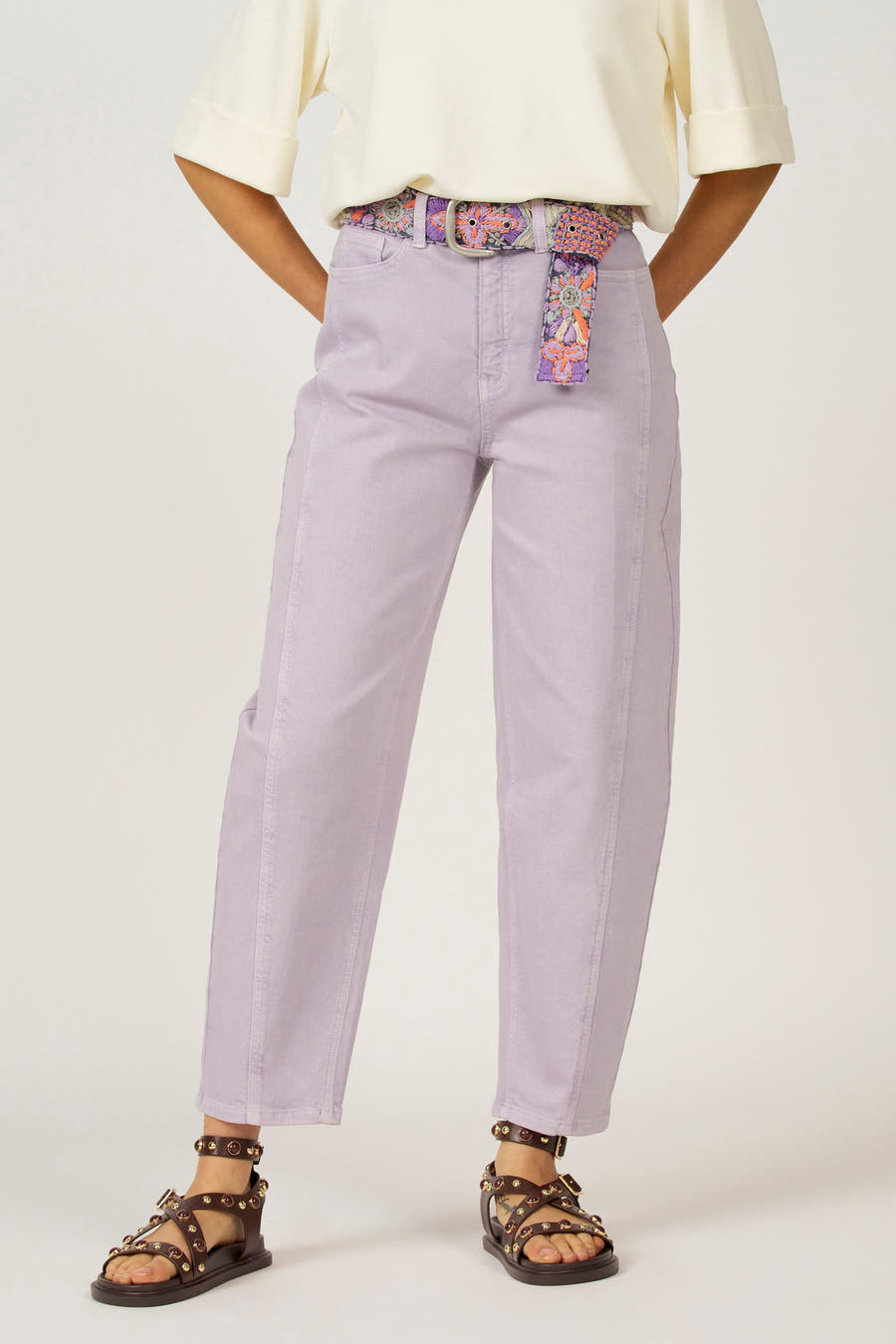 Paarse colorbroek van Astrid Black Label, met een opvallende gebloemde riem en bruine sandalen.
