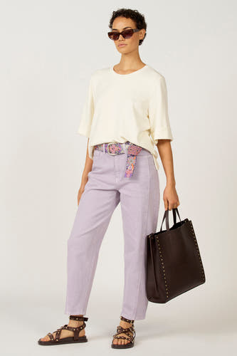 Jean bleu marine d'Astrid Black Label, avec une ceinture fleurie et associé à des sandales brunes et un sac.