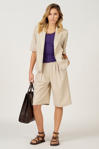 Ecru blazer van Astrid Black Label, met korte mouwen en gedragen over een paarse top en kaki bermuda.