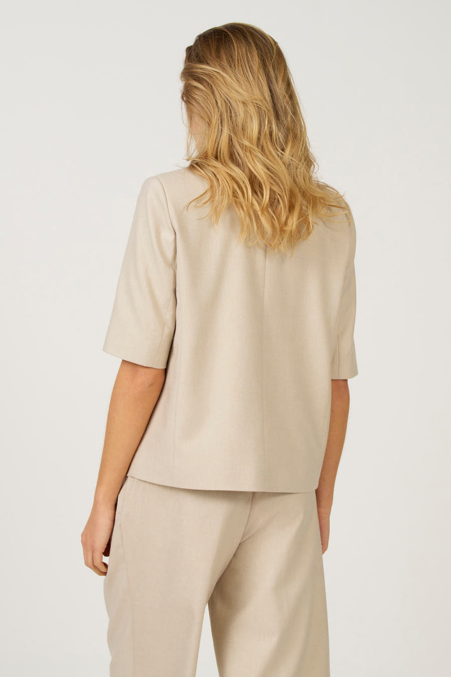 Ecru blazer van Astrid Black Label, gezien van achteren met korte mouwen en bijpassende broek.
