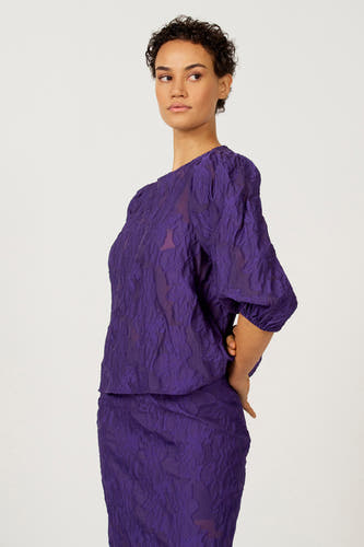 Paarse blouse met driekwart mouwen van Astrid Black Label, met een jacquard bloempatroon en pofmouwen.
