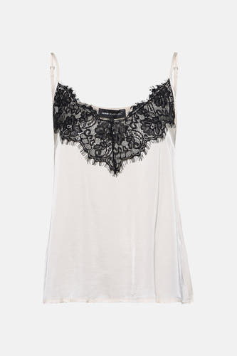 Ecru mouwloze blouse van Astrid Black Label, met zwart kanten details langs de halslijn.