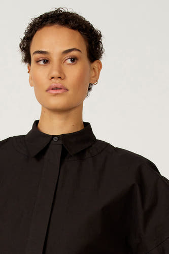 Zwarte blouse van Astrid Black Label, met korte mouwen en een klassieke kraag.