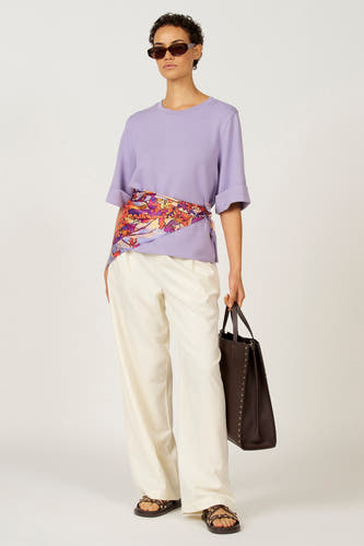 T-shirt violet à manches courtes d'Astrid Black Label, stylé avec un foulard et un pantalon beige.
