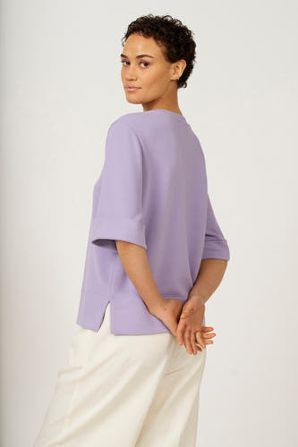 T-shirt violet à manches courtes d'Astrid Black Label, avec des manches retroussées et un short blanc.