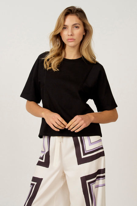 Zwart T-shirt met korte mouwen van Astrid Black Label, met rechte pasvorm en gecombineerd met een broek met grafische print.
