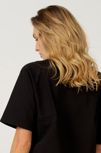 T-shirt noir à manches courtes d'Astrid Black Label, vu de l'arrière, avec une coupe droite et un détail de poche simple.