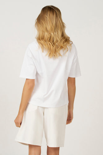 Wit T-shirt met korte mouwen van Astrid Black Label, gezien van achteren, gecombineerd met een witte korte broek.