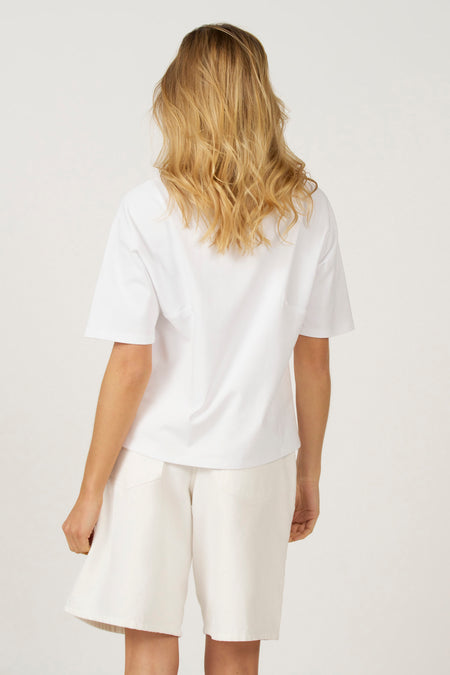 Wit T-shirt met korte mouwen van Astrid Black Label, gezien van achteren, gecombineerd met een witte korte broek.