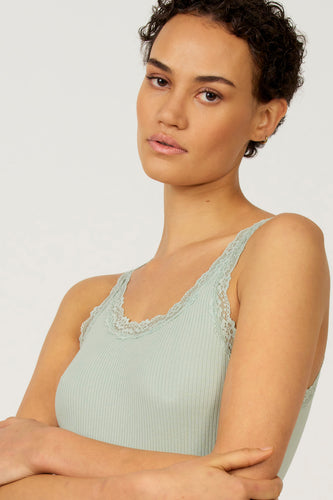 Groene singlet van Astrid Black Label, met kanten details langs de halslijn en schouderbanden.