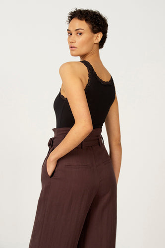 Zwarte singlet van Astrid Black Label, met kanten rand, gecombineerd met een bruine pantalon.