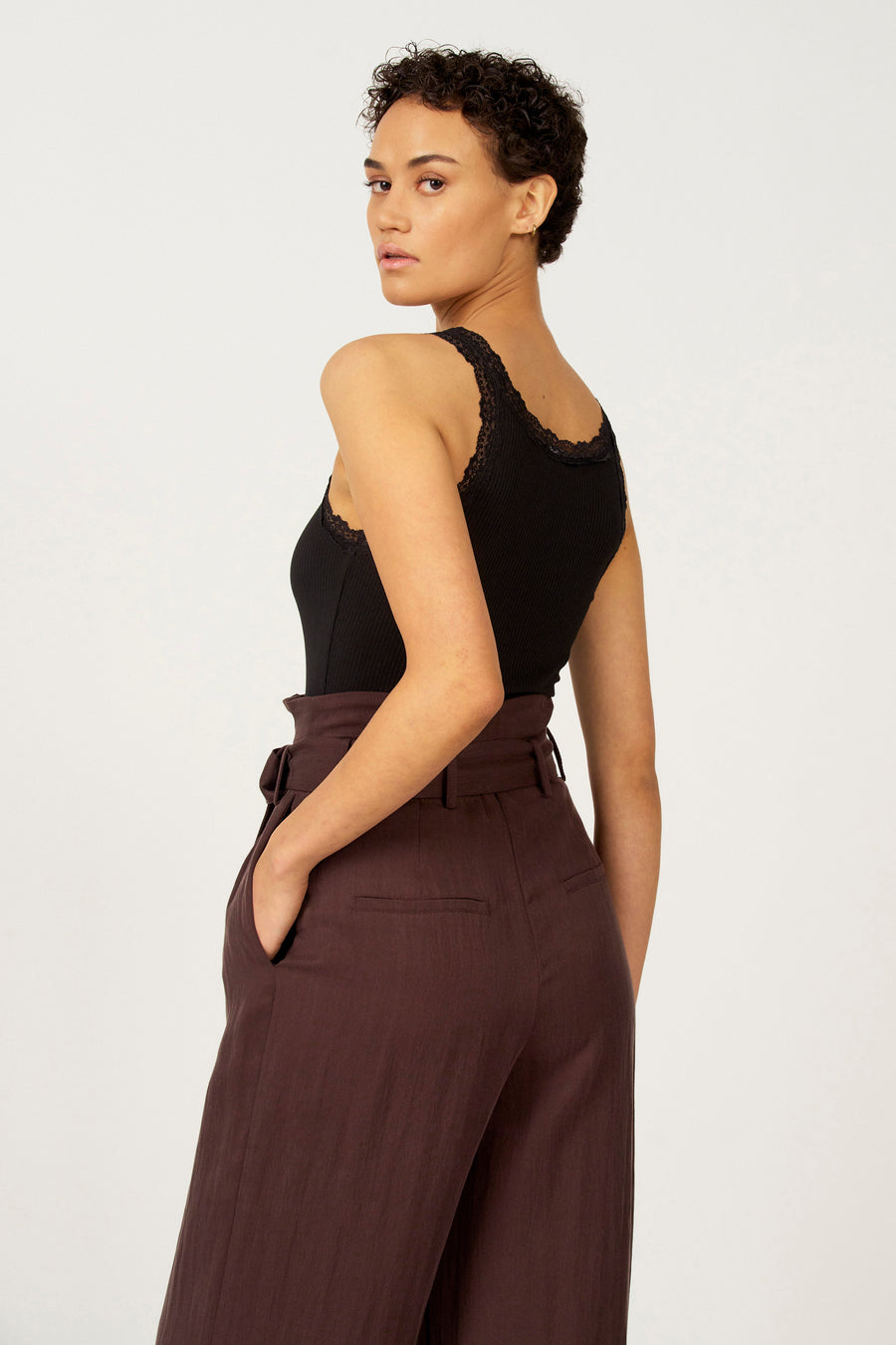 Zwarte singlet van Astrid Black Label, met kanten rand, gecombineerd met een bruine pantalon.