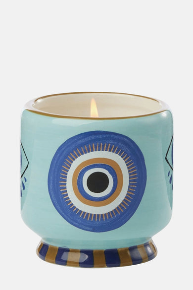Multicolor kaars van PADDY WAX, met een opvallend oogpatroon in blauw, goud en zwart.
