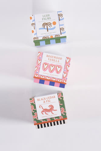 Multikleurige kaarsen van PADDYWAX, met palmboom-, hart- en tijgerpatronen in verschillende kleuren.
