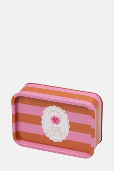 Roze kaars van PADDY WAX, gestreept met oranje accenten en een decoratief etiket.