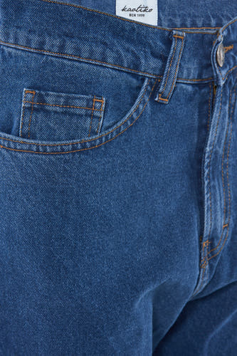 Jean large en denim bleu de KAOTIKO, avec une petite poche et des coutures marron.