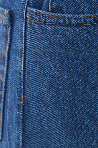 Jean large en denim mid blue de KAOTIKO, avec des coutures orange et une texture denim subtile.