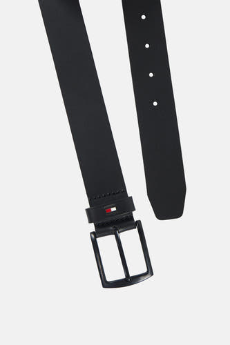 Zwarte riem van TOMMY JEANS, diagonaal getoond, met een metalen gesp, perforaties en vlaglogo op de passant.
