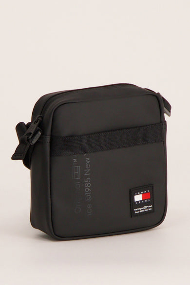 Zwarte schoudertas van TOMMY JEANS, met een geweven band en het merklogo.