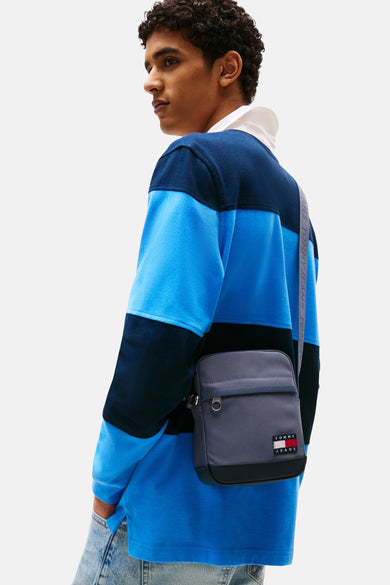 Sac à dos bleu de TOMMY JEANS, avec une sangle épaule grise et de petits détails.