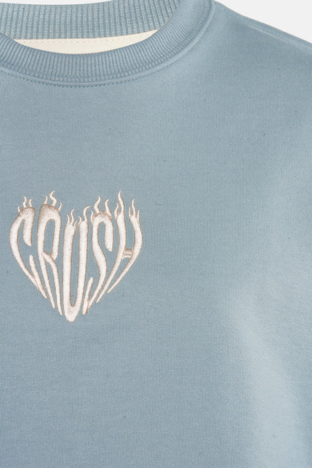 Turquoise sweater van KAOTIKO met een hartvormig 'CRUSH' design.
