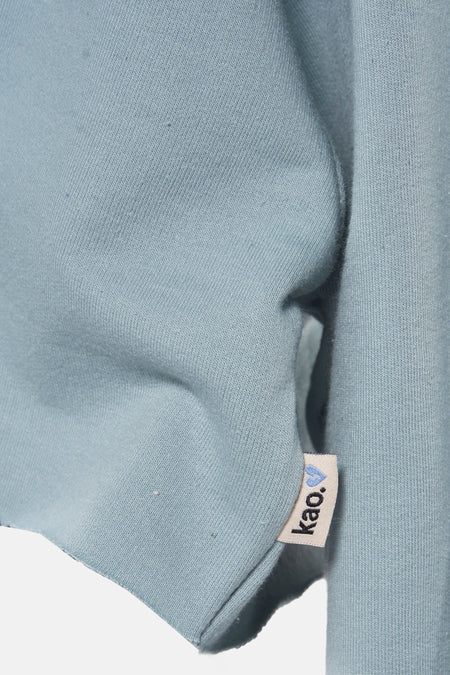 Turkooizen sweater van KAOTIKO, met merklabel en zachte stoftextuur.
