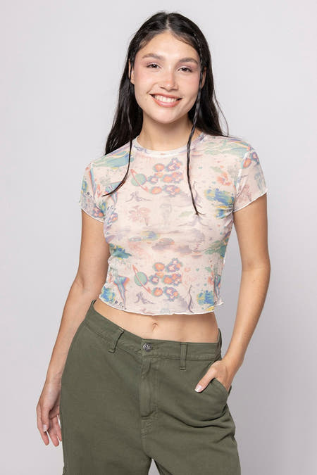 Ecru T-shirt van KAOTIKO, met een all-over print van planeten, gedragen met een groene broek.