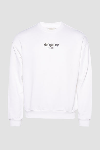 Witte sweater van KAOTIKO met tekstprint op de borst, tegen een effen grijze achtergrond.
