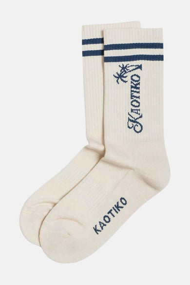 Ecru sokken van KAOTIKO met blauwe strepen en merklogo met palmboom motief.