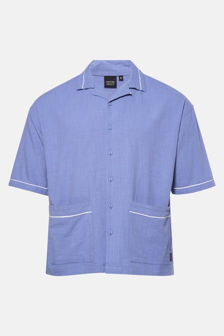 Chemise bleue à manches courtes de KAOTIKO, avec des accents blancs sur le col et les poches.