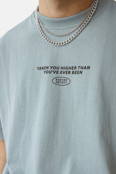 T-shirt bleu à manches courtes de KAOTIKO, avec une impression de texte noire et des chaînes d'argent.