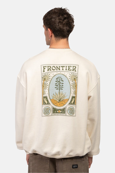 Gilet écru de KAOTIKO, avec une impression graphique sur le dos représentant un paysage désertique et le mot 'Frontier'.