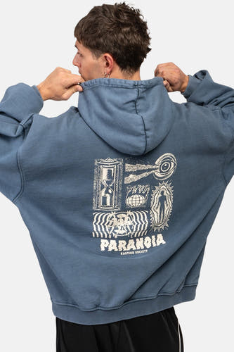 Blauwe hoodie van KAOTIKO met grafische print op de rug, losse pasvorm en zwarte broek.