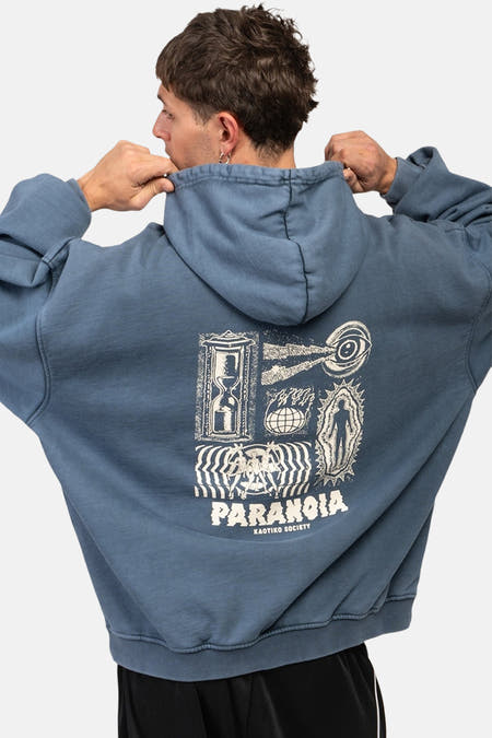 Blauwe hoodie van KAOTIKO met grafische print op de rug, losse pasvorm en zwarte broek.